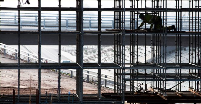 T3KGA0 Construction worker in a scaffolding at a building.